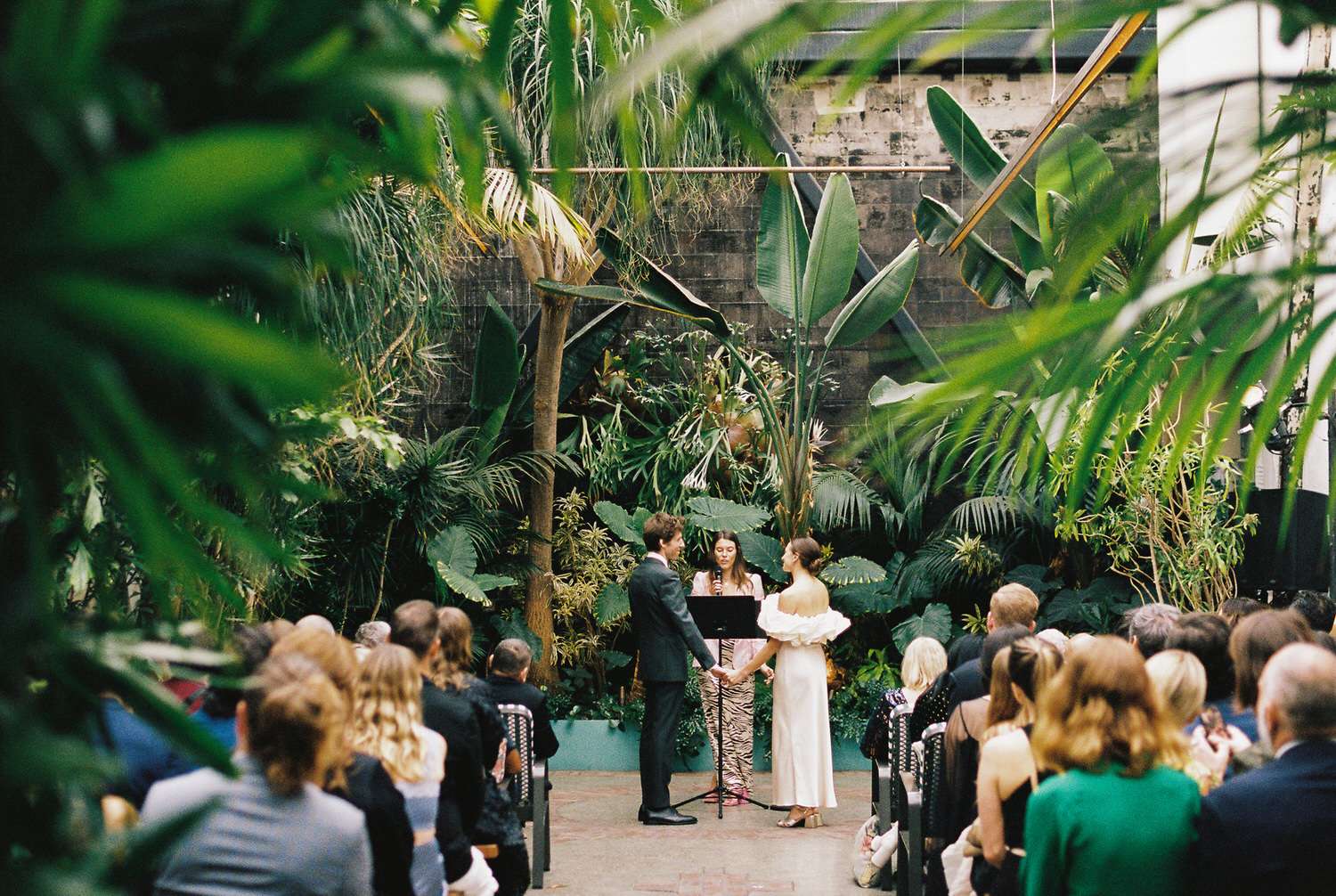 Bride and groom at Grass Room wedding ceremony inside urban greenhouse in Los Angeles.