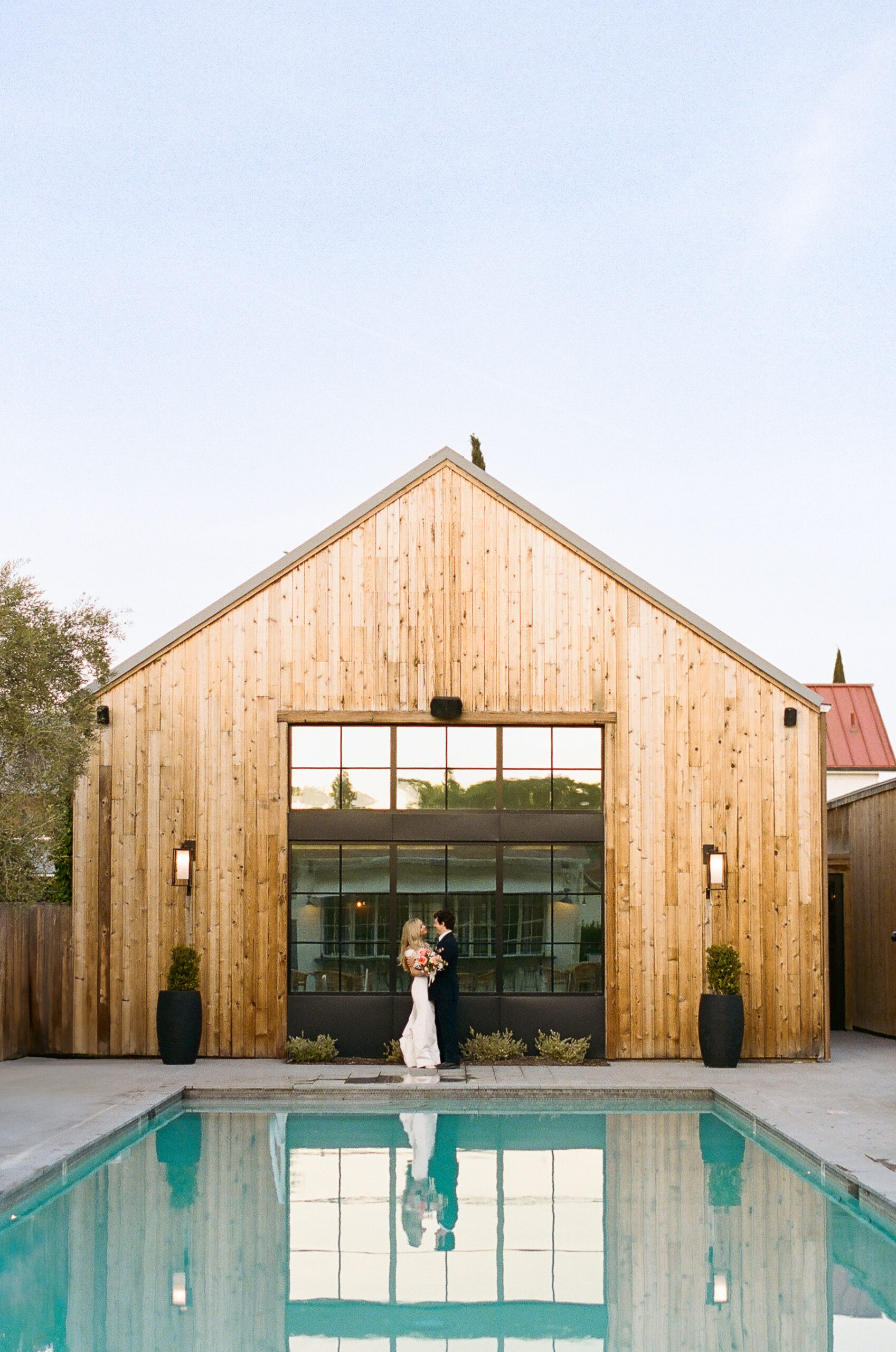 bride and groom in front of barn at the inn at mattei's tavern wedding